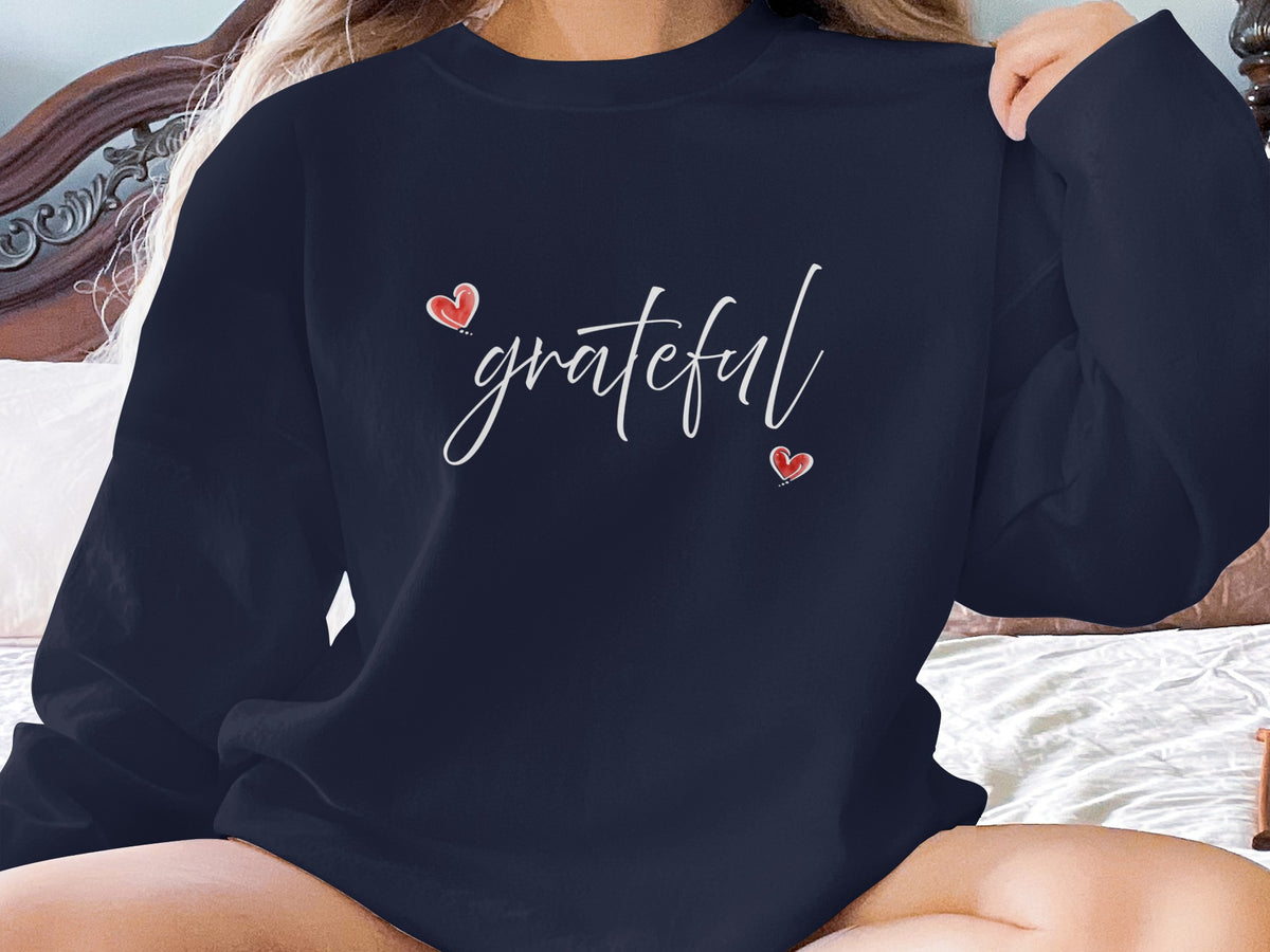 Navy Grateful Heart crewneck sweatshirt featuring handwritten-style white grateful script framed by two red heart accents