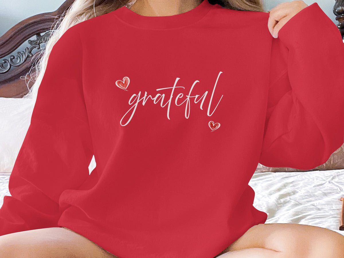 Red Grateful Heart Sweatshirt highlighting white flowing typography and two hand-drawn hearts around the gratitude message.