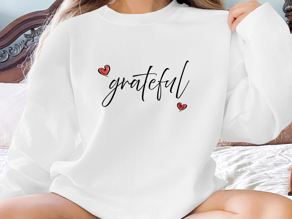 White Grateful Heart Sweatshirt with contrasting red hearts and flowing black grateful script across the chest.