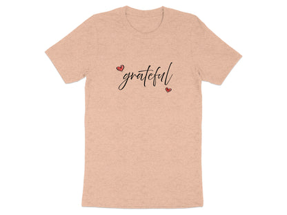 Heather peach Grateful Heart T-Shirt featuring handwritten-style black script and red heart details in a diagonal composition.