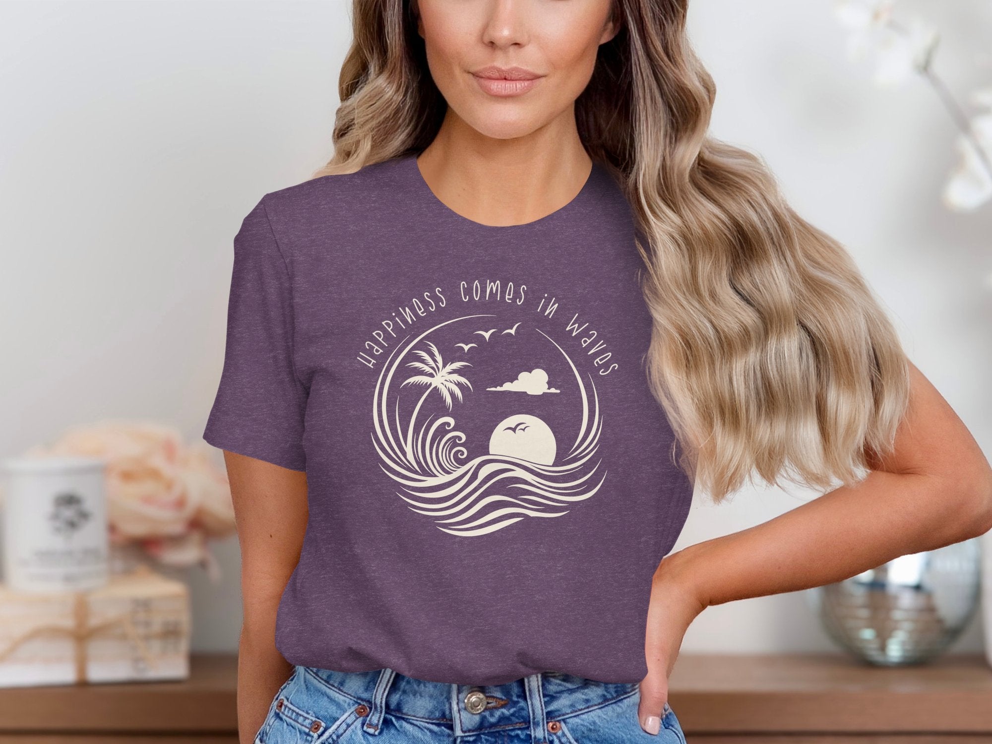 Heather Purple Happiness Comes In Waves T-Shirt displaying a circular beach graphic with waves and a setting sun.