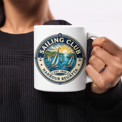 11oz Harbour Regatta Sailing Club ceramic mug held in hand, showing four white-sailed yachts, blue water and colourful maritime artwork.