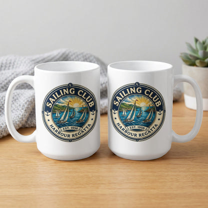 Two white 15oz ceramic coffee mugs showing front and back with HARBOUR REGATTA, EST. 1956, anchors and a navy rope-bordered crest.