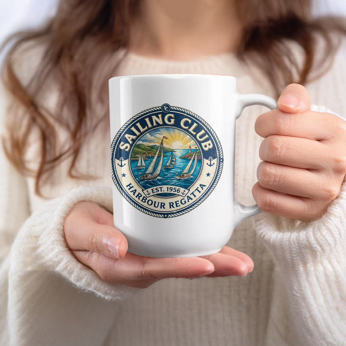 White 15oz Harbour Regatta Sailing Club Mug held in hand, showing four yachts, a red pennant and golden-yellow sunburst sky.