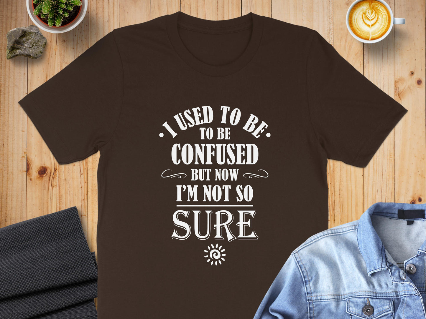 Brown I Used To Be Confused T-Shirt featuring humorous vintage-style quote artwork with decorative typography and spiral sun motif.
