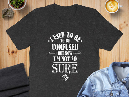 Charcoal Heather I Used To Be Confused T-Shirt showcasing retro typography, oversized focal text, and ornamental flourish accents.