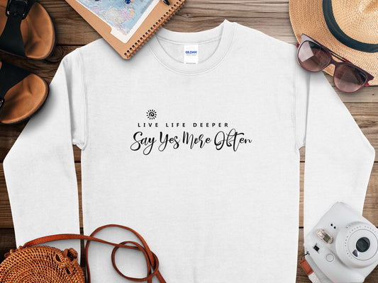 Live Life Deeper sweatshirt featuring centre-chest quote typography Live Life Deeper, Say Yes More Often with spiral sun motif.