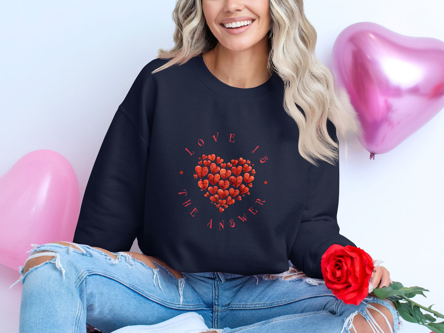 Navy Love Is the Answer crew neck pullover with uplifting quote, soft fabric, heart design and classic relaxed silhouette.