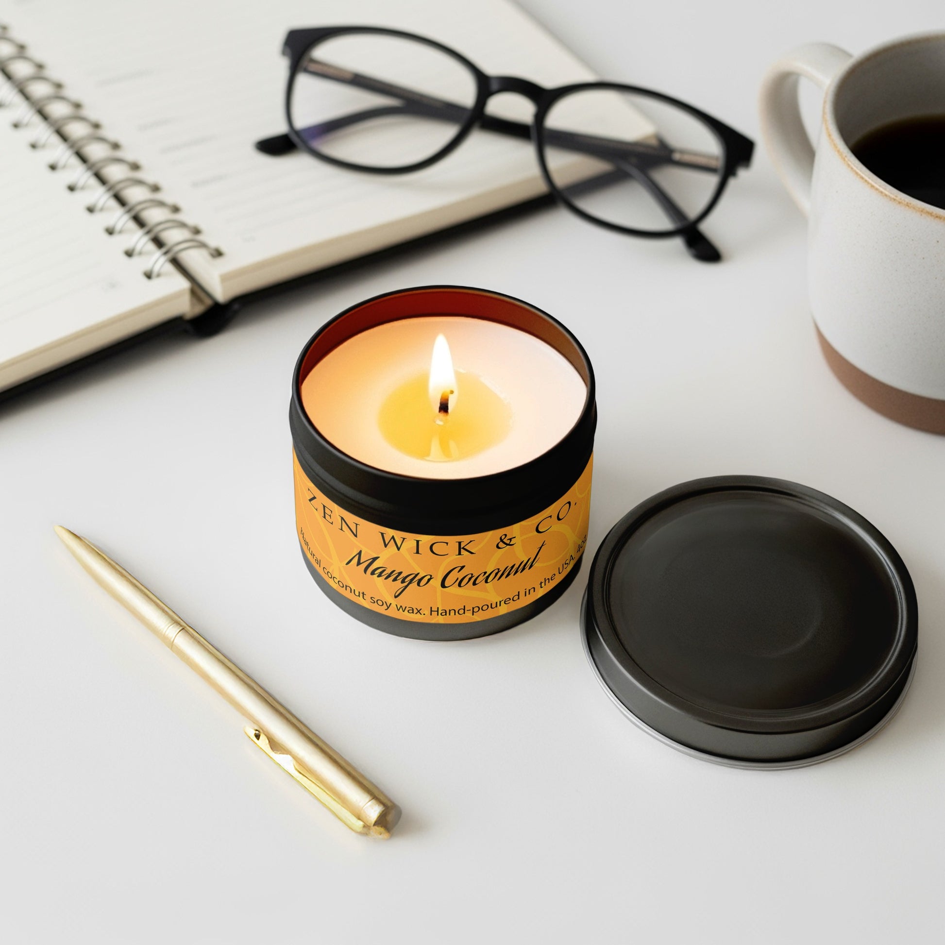 Mango coconut scented candle 4oz lit with surrounding decor creating a fresh and uplifting tropical setting.