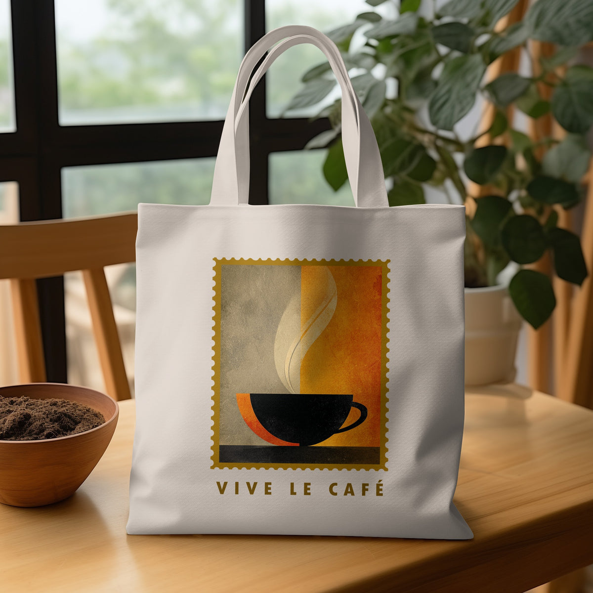 Minimalist Coffee & Steam Tote Bag with black cup, olive-grey and burnt orange fields and VIVE LE CAFE lettering on wooden table.