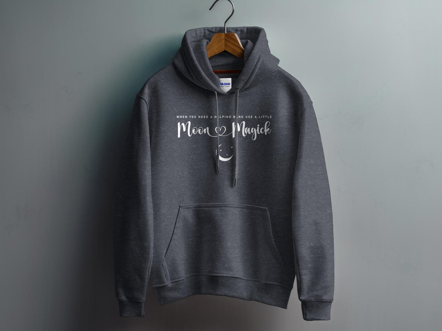 Dark Heather Grey Moon Magick Hoodie with elegant Moon Magick script lettering and small crescent moon illustration in a balanced chest design.