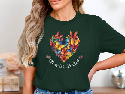 Forest green One World One Heart T-shirt with centred multicolour butterfly heart graphic and soft white handwritten unity text.