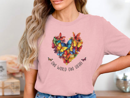 Pink One World One Heart T-shirt featuring vibrant butterfly heart design across chest with handwritten One World One Heart detail.