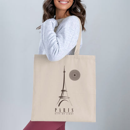 Paris City of Light Tote Bag worn over the shoulder, showing the full Eiffel Tower graphic and minimalist Paris typography beneath.