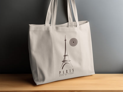 Paris City of Light canvas tote bag displayed on a sideboard, showing the dark brown Eiffel Tower artwork and spaced PARIS lettering beneath.