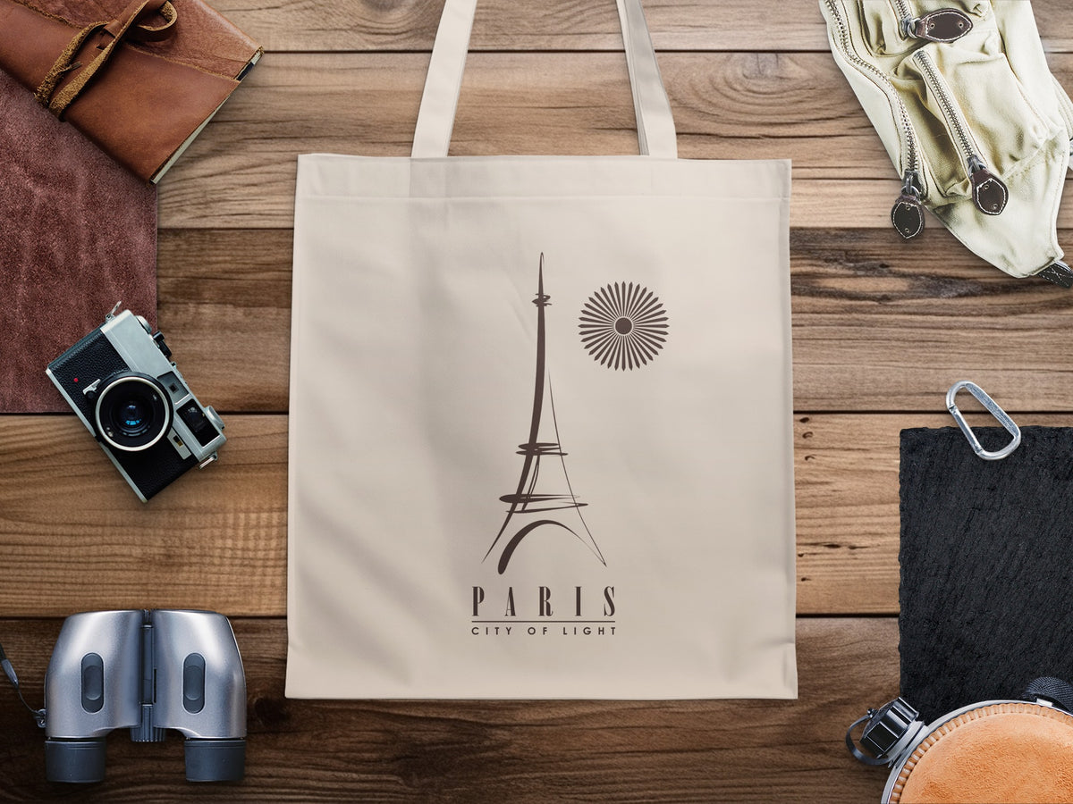 Paris City of Light Tote Bag featuring minimalist Eiffel Tower line art, a radial sunburst motif and elegant typography on natural canvas.