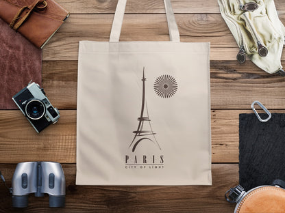 Paris City of Light Tote Bag featuring minimalist Eiffel Tower line art, a radial sunburst motif and elegant typography on natural canvas.