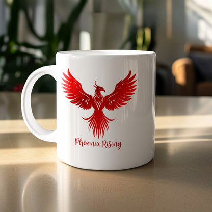 White ceramic Phoenix Rising Mug featuring a large red phoenix in flight, detailed feather linework and flowing red script lettering.