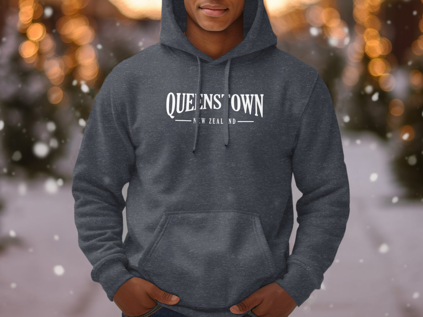 Dark heather grey Queenstown New Zealand hoodie with arched lettering and vintage travel souvenir-style chest graphic.