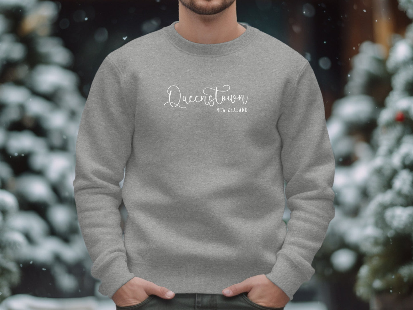 Graphite heather Queenstown Sweatshirt with white editorial script Queenstown and destination typography layout.