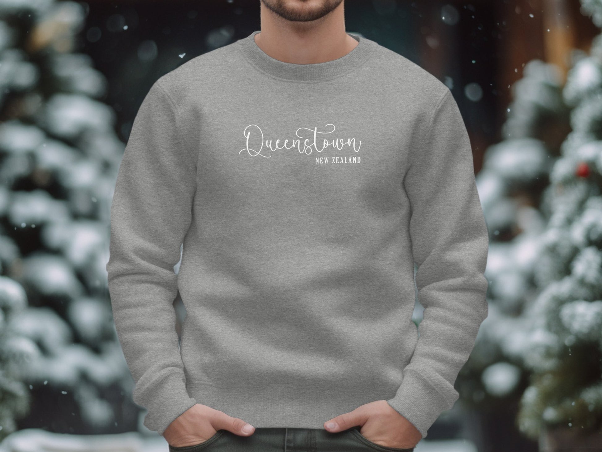 Graphite heather Queenstown Sweatshirt with white editorial script Queenstown and destination typography layout.
