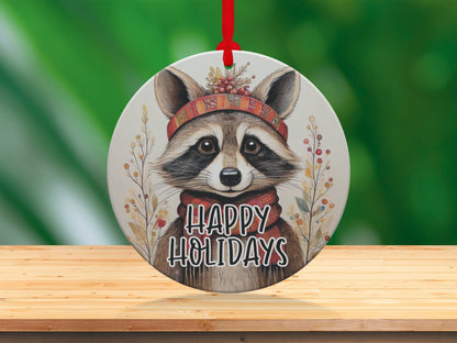 Woodland animal ornament featuring a watercolour raccoon against a warm ivory background with seasonal foliage.