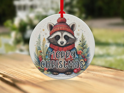 Festive raccoon artwork featuring bright red winter accessories, pine branches, and cheerful Christmas lettering.