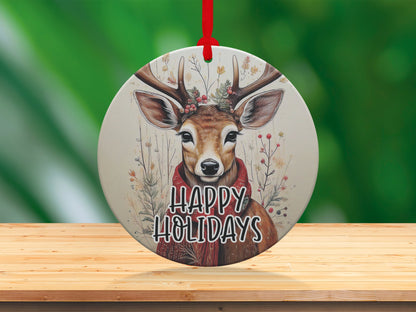 Round holiday ornament with watercolour deer artwork, floral stems, red scarf, and botanical Christmas details.