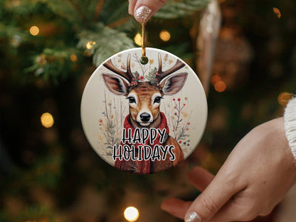 Watercolour reindeer ceramic ornament with holly-adorned antlers, red scarf, and delicate winter wildflower accents.