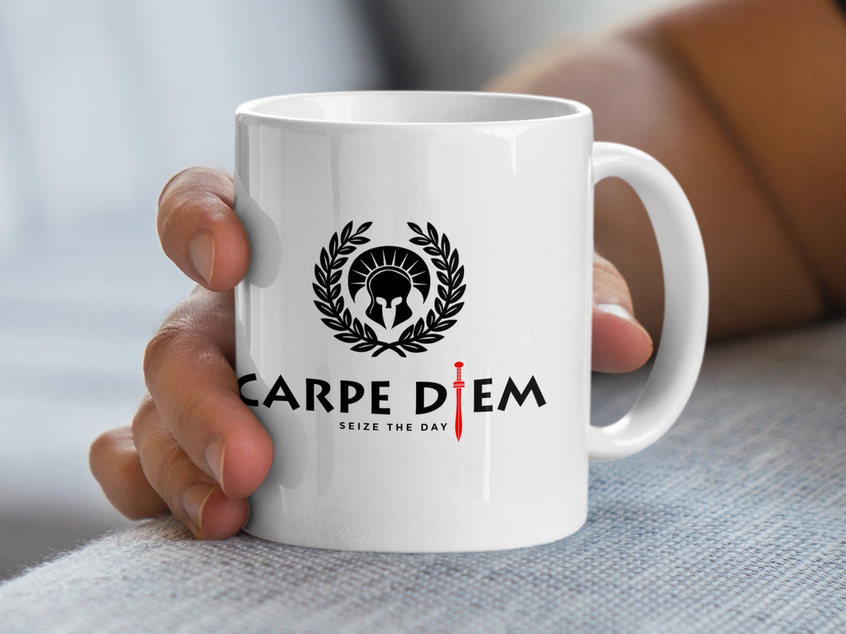 White 11oz Seize the Day ceramic mug held in hand, showing the Roman helmet, laurel wreath and contrasting red gladius sword.
