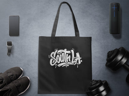 Black South L.A. Tote Bag in a gym setting, highlighting loose brush lettering, splatter marks and streetwear styling.