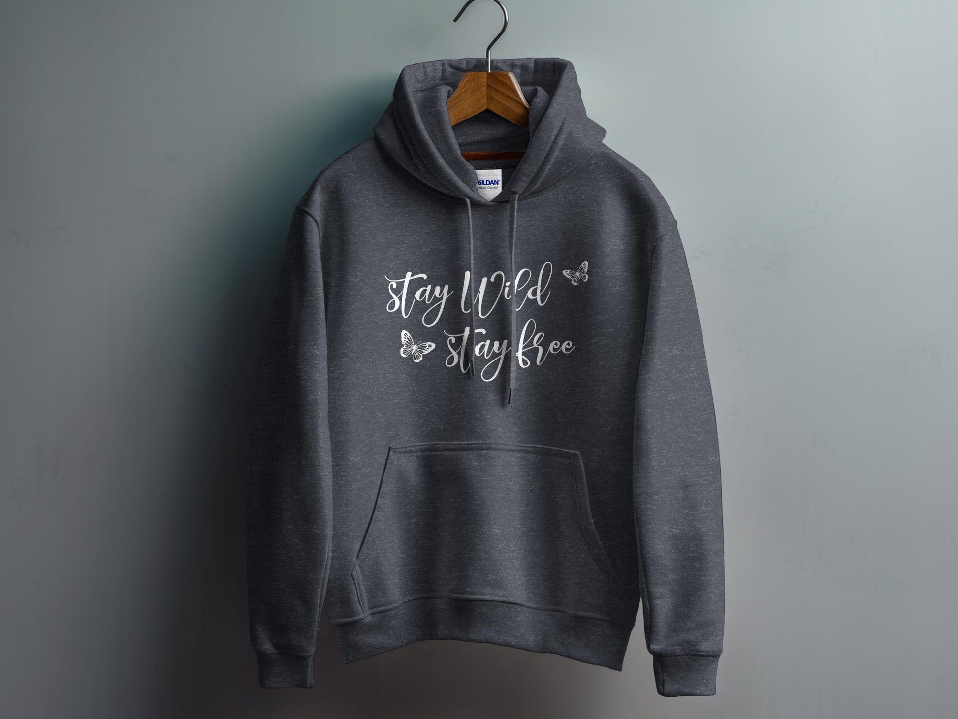 Dark Heather Grey Stay Wild Stay Free Hoodie featuring free-spirited Stay Wild script lettering with delicate butterfly outlines.