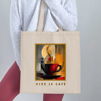Steam & Geometry Tote Bag held by a woman, with sweeping cream steam, deep-red cup, gold border and VIVE LE CAFE lettering.