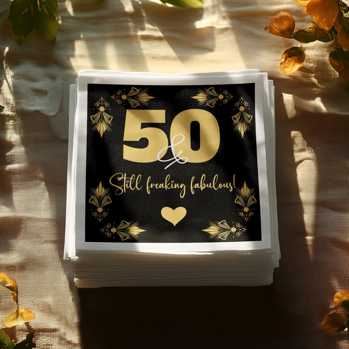 Custom birthday napkins displaying a gold milestone year with Still Freaking Fabulous script and heart detail.