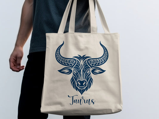 Taurus Tote Bag featuring ornate navy bull artwork above elegant Taurus script with intricate horn detailing.