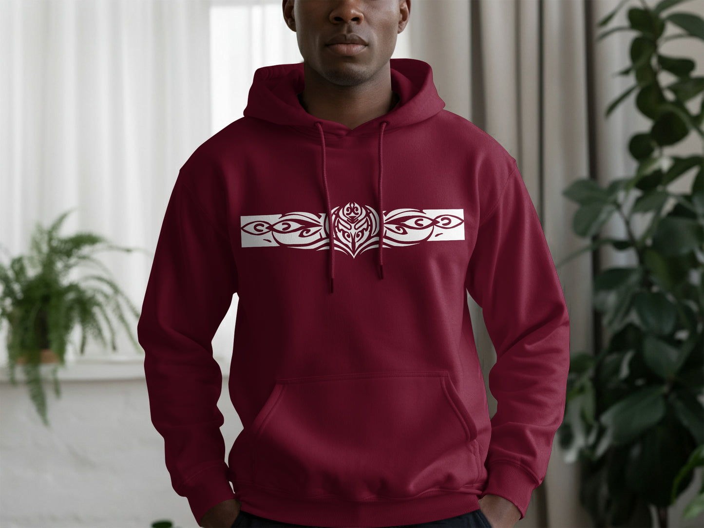 Maroon hoodie with tribal-inspired artwork, front pouch pocket, brushed fleece texture, and urban streetwear style.
