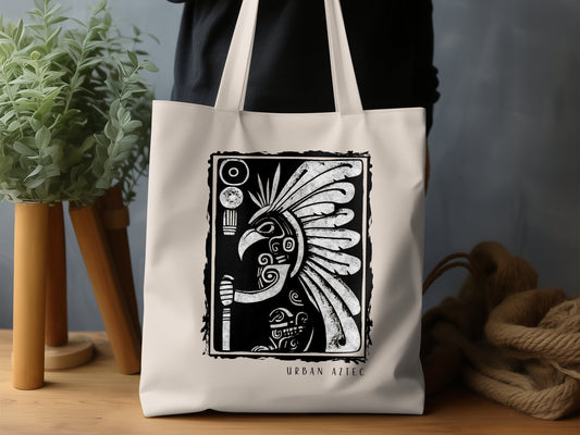 Urban Aztec Tote Bag Edition 2 displaying woodblock-style artwork with glyph elements and ornate scroll patterns.