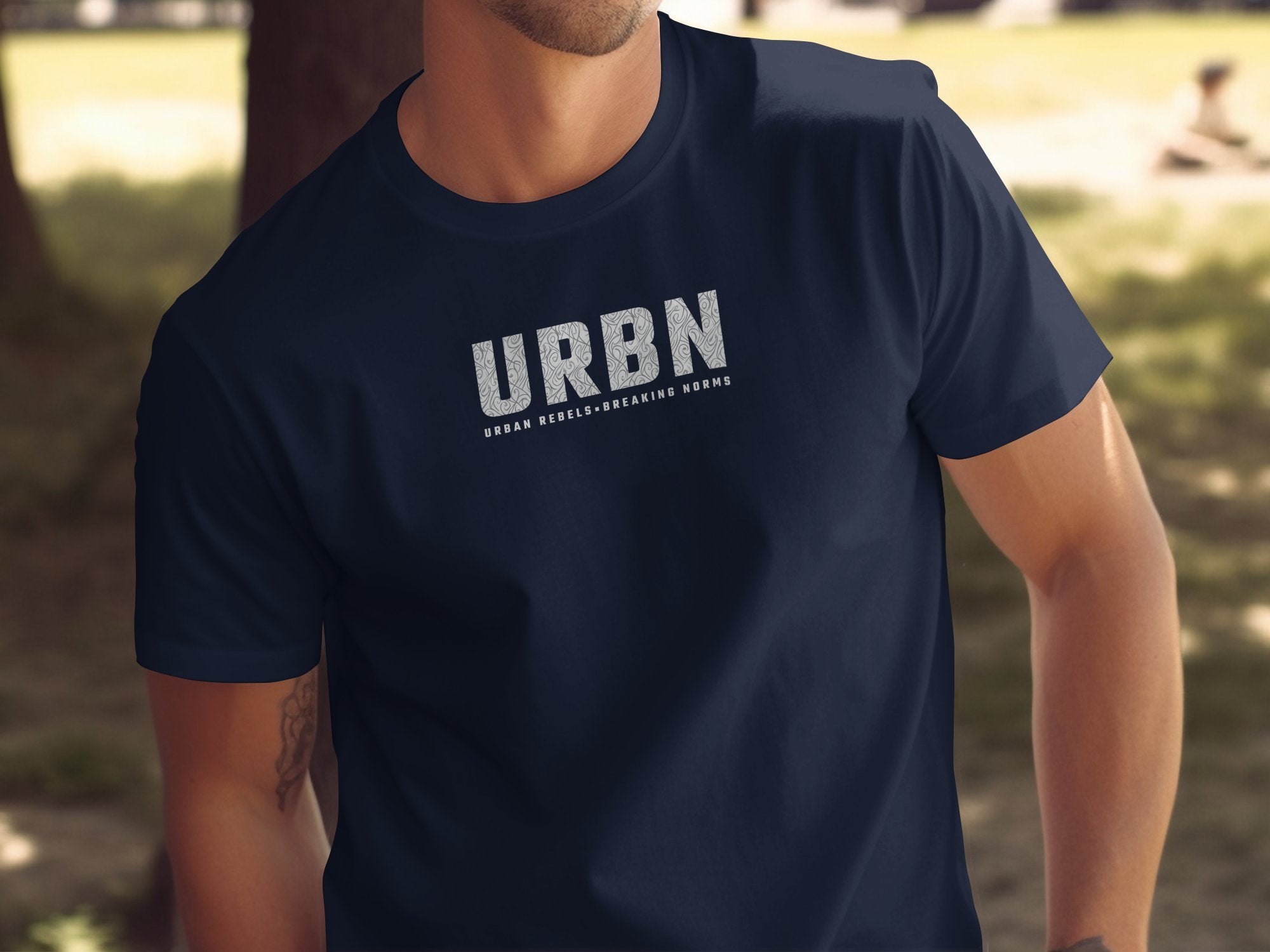 Navy URBN T-shirt with chest‑placed wide URBN lettering, subtle contour line detail, and a clean supporting tagline.