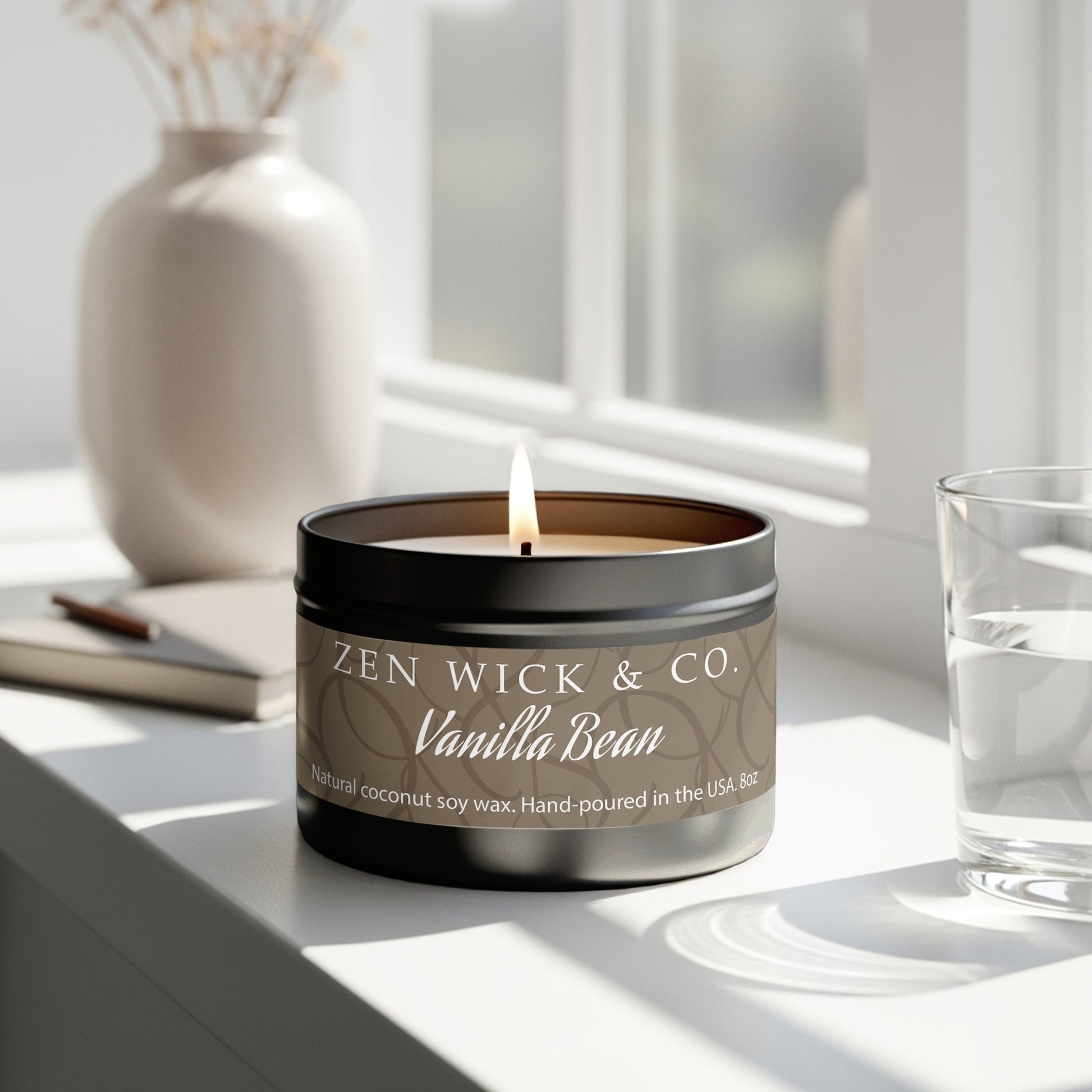 Vanilla bean scented tin candle 8oz burning beside window with natural light creating a calm relaxing mood.