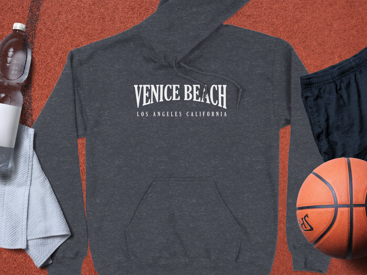 Dark heather grey Venice Beach hoodie with monochrome serif chest print and West Coast-inspired destination styling.