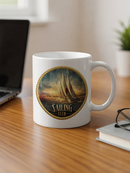Vintage Sailing Club 11oz ceramic mug on office desk with classic nautical yacht emblem and rope border.