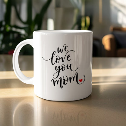 We Love You Mom 11oz ceramic mug on table with glossy finish, perfect for daily coffee or tea moments.
