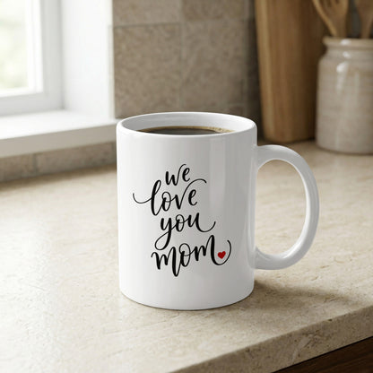We Love You Mom 11oz ceramic mug on kitchen counter, a stylish and practical gift for moms who love coffee.