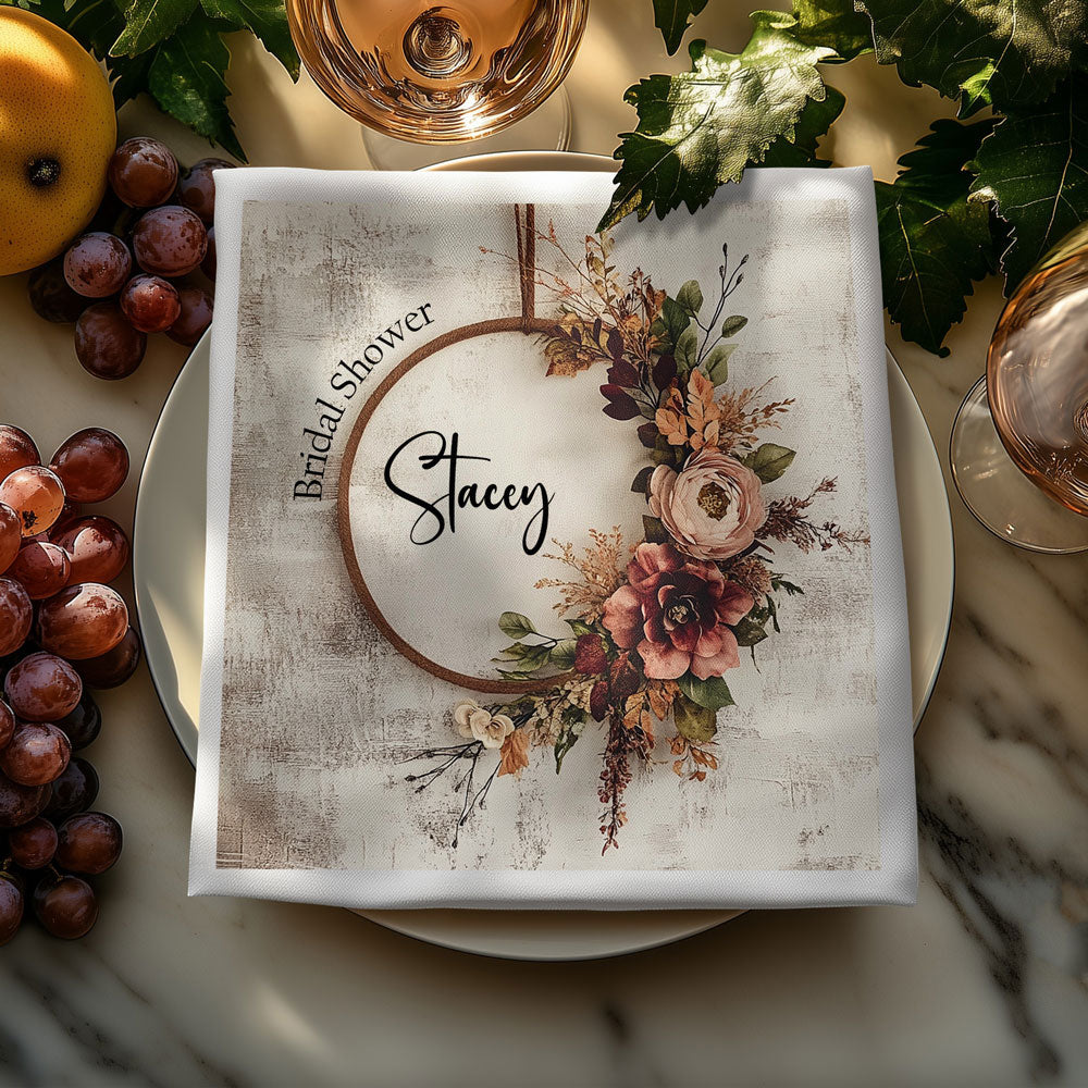 Custom bridal shower 3-ply napkin with boho floral wreath and personalised name on an elegant wedding table setting.