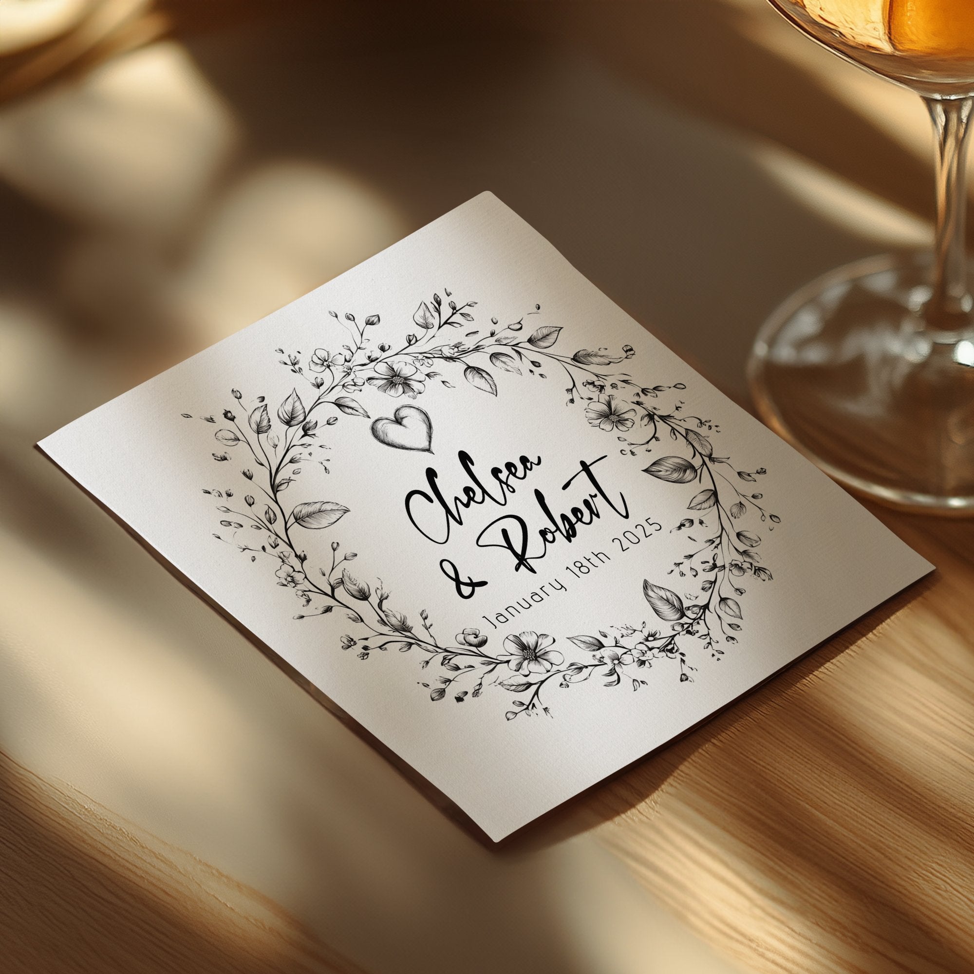 Custom wedding cocktail napkin featuring wildflower stems, delicate leaves and personalised details.
